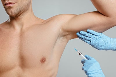 Man receiving Botox injection in underarm