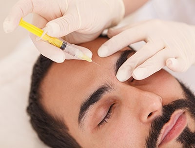 Man receiving Botox injection to forehead