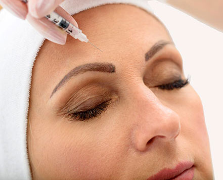 Woman receiving Botox injection in forehead