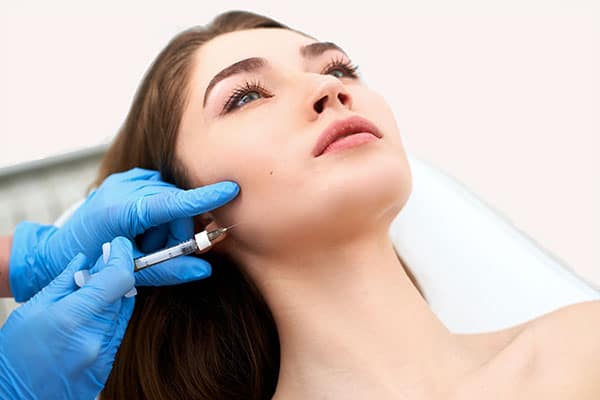 Woman receiving dermal filler in jawline