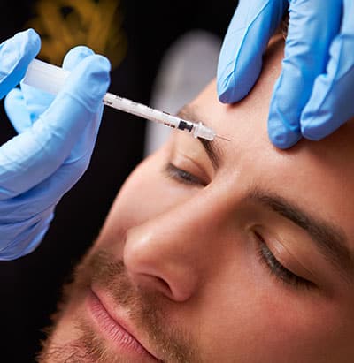 Man receiving Dysport injection in forehead