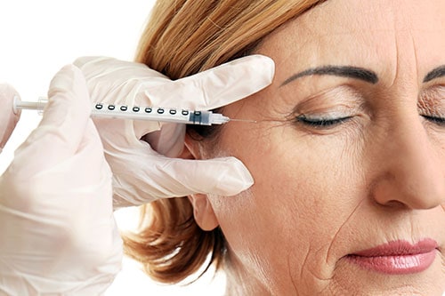 Woman receiving Botox injection near eye