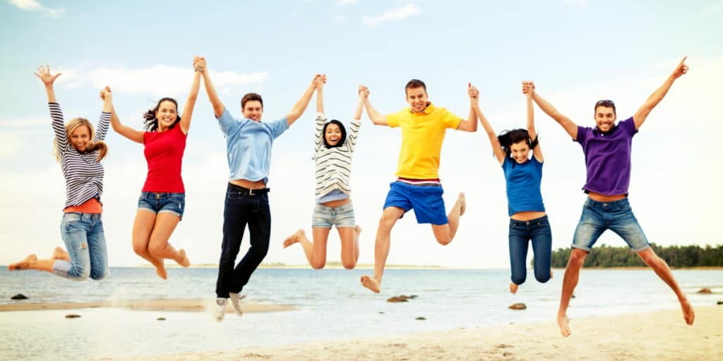 Group of happy people jumping in the air on a beach